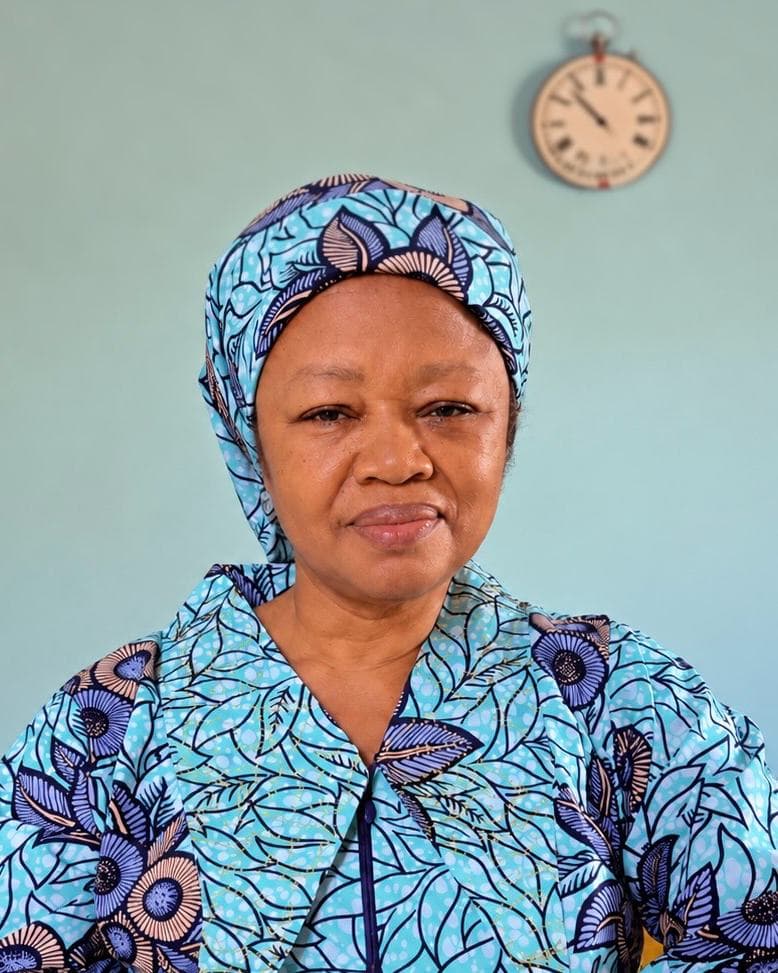 Mrs Egbo in a turquoise and violet floral print, calm and composed